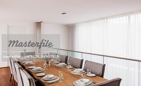 Modern, luxury home showcase interior dining room with placesettings on dining table