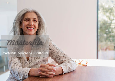 Portrait smiling, confident mature businesswoman sitting at table