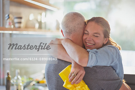 Happy couple hugging in kitchen