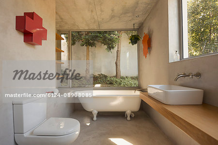 Modern, minimalist luxury bathroom with soaking tub and windows