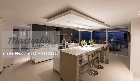 Illuminated modern luxury home showcase interior kitchen at night
