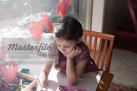 High angle view of girl sitting at table drawing