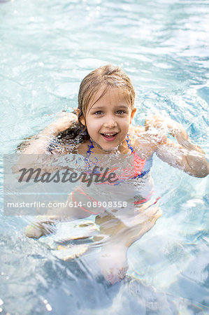 Portrait of girl treading water in outdoor swimming pool