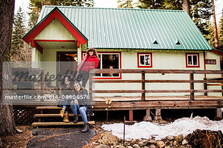 Portrait of three friends in front of cabin