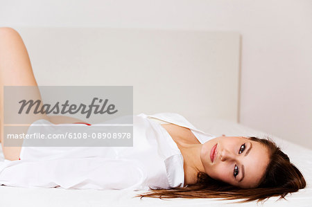Yong woman seducing camera lying on the bed