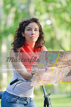 Woman with map and bicycle doing a tour