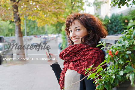 Young pretty woman texting with smartphone at the street in Berlin