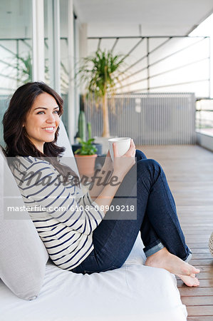 Beautiful woman enjoying a warm drink in the terrace