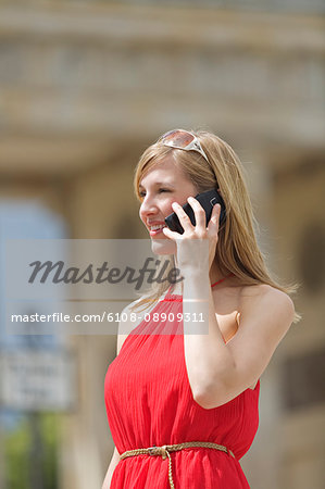 Pretty blonde woman doing sightseeing in Berlin and talking on the phone