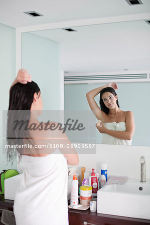Brunette woman aplying deodorant