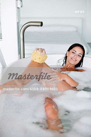 Young pretty brunette woman enjoying a bath