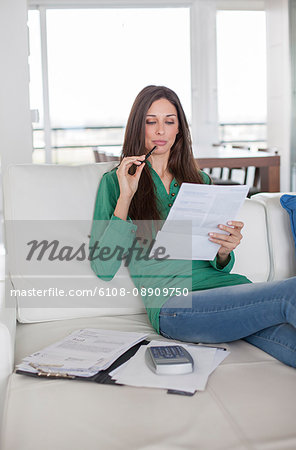 Brunette woman checking bill at home