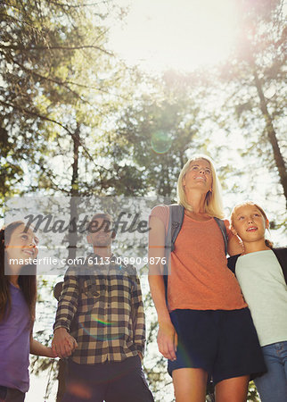 Family hiking in sunny woods