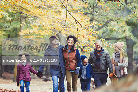Multi-generation family walking in autumn woods