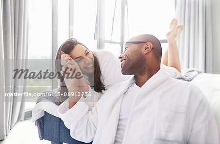 Affectionate couple holding hands in bedroom
