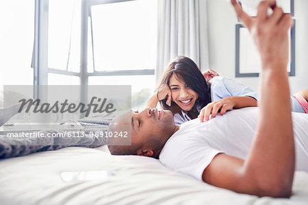 Smiling couple laying and relaxing on bed