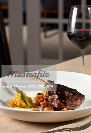 Bone in rib eye steak with red wine on white plate, David's Restaurant, Amelia Island, FL.