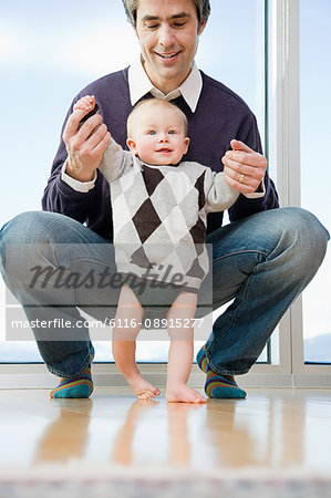 father helping his son walk