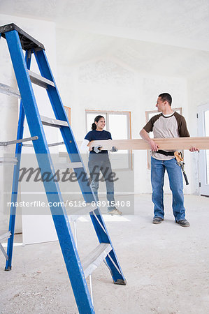 A couple holding a plank of wood