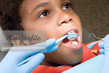 Boy having teeth examined