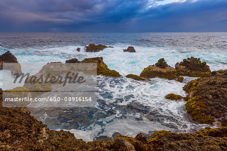 Atlantic Ocean and lava rock coast at dawn at Charco del Viento in La Guancha on Tenerife in the Canary Islands, Spain Atlantic Ocean and lava rock coast at dawn at Charco del Viento in La Guancha on Tenerife in the Canary Islands, Spain
