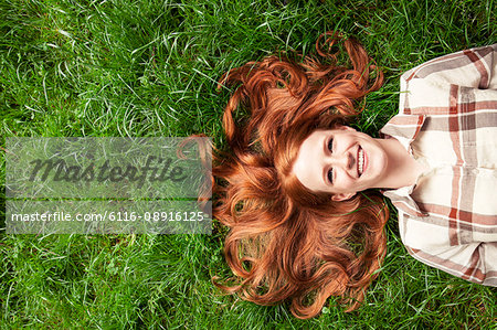 Teenage girl laying in grass