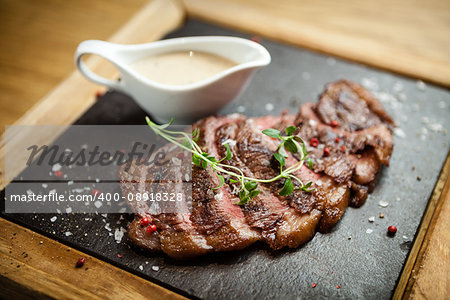 Sliced steak Picanya with sauce served on s stone board