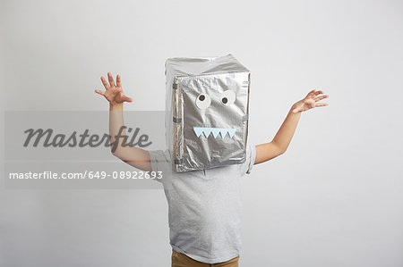 Portrait of boy with silver box on head, funny face on box