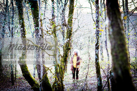 Mature woman strolling in woodland