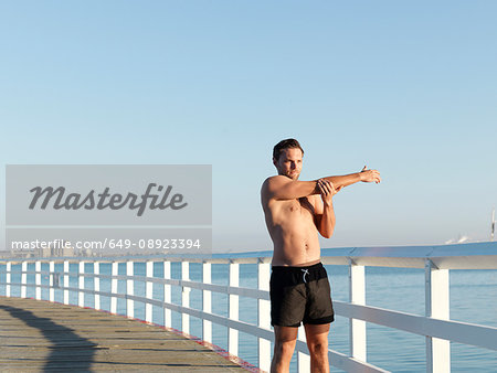 Swimmer stretching on boardwalk, Eastern Beach, Geelong, Victoria, Australia