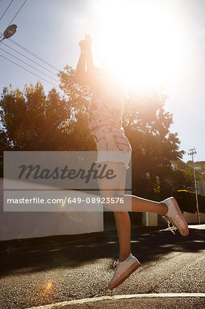 Teenage girl jumping in street, Cape Town, South Africa