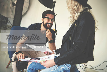 Photographer and stylist having discussion in photography studio