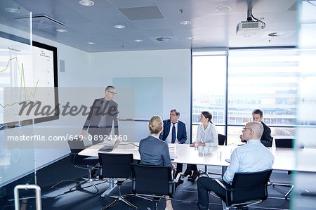 Businessman making flat screen presentation to team in boardroom