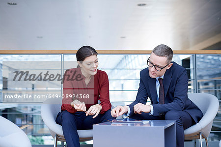 Businesswoman and man having meeting on office balcony