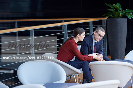Businesswoman and man having meeting on office balcony