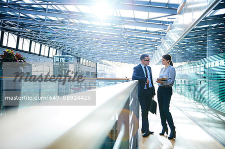 Businessman and woman meeting on office balcony