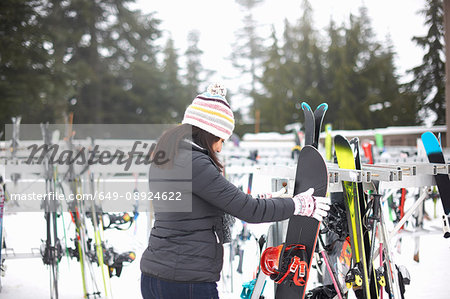 Woman selecting ski equipment, Vancouver, Canada