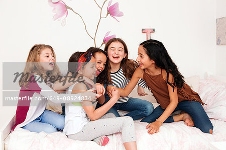 Girls on bed fooling around laughing