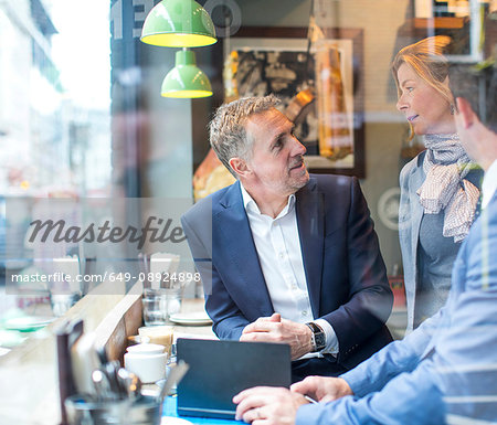 Businessmen and woman having working lunch in restaurant