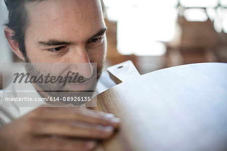 Close up of man inspecting chopping board in factory