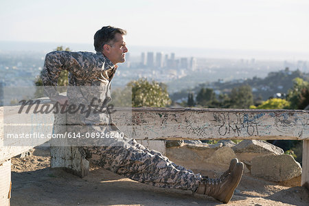 Soldier wearing combat clothing doing reverse push up, Runyon Canyon, Los Angeles, California, USA