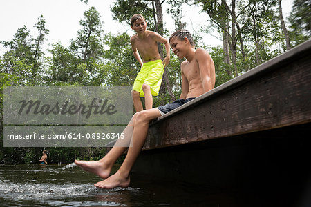 Boys wearing swimming shorts on jetty, Turkey Creek, Niceville, Florida, USA