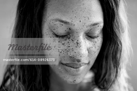 Portrait of freckled woman with eyes closed