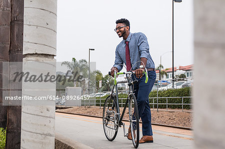 Young businessman cyclist on rail station platform