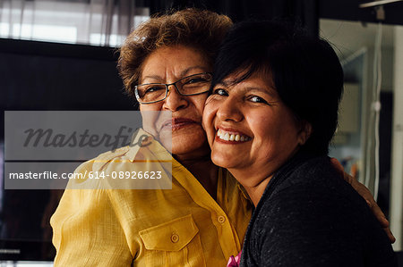 Portrait of mother and adult daughter hugging