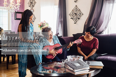 Grandmother playing guitar for family