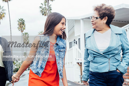 Grandmother and granddaughter walking in street