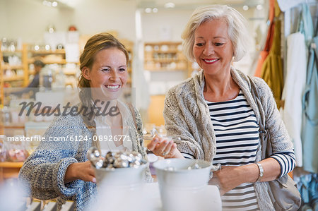 Smiling mother and daughter browsing merchandise in shop