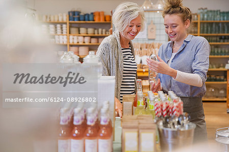 Shop owner showing products to female shopper in shop
