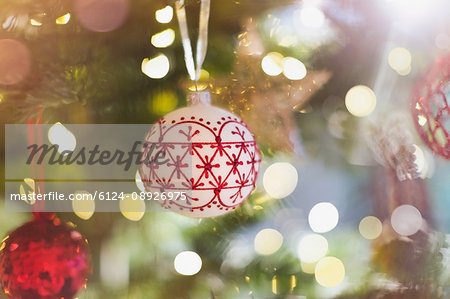 Red and white ornament hanging from Christmas tree